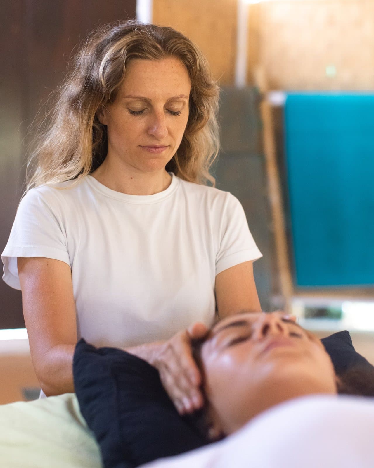 Vanessa with her hands resting gently either side of a client's head during a private Reiki session